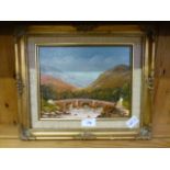 A gilt framed oil on board of bridge in mountain scene