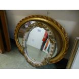 Two ornate framed oval mirrors