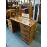 A modern pine dressing table having a bank of four drawers with a detachable swing mirror to back