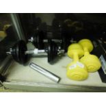 A pair of metal and iron dumbbells together with a pair of plastic dumbbells