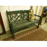 A green painted weathered wooden garden bench