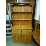 A modern pine dresser having plate rack to top,