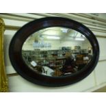 An early 20th century mahogany framed oval bevel glass mirror