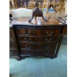 A reproduction mahogany serpentine fronted chest of four drawers with brush slide