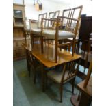 A mid 20th century walnut extending dining table along with a matching set of five (3+2) dining