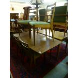 A mid 20th century teak extending dining table along with a set of four matching chairs,