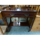 An Edwardian walnut single drawer writing table on turned legs with under tier