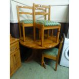 A modern pine circular drop leaf table with a set of four matching chairs