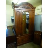 A Victorian mahogany wardrobe having a mirrored centre door with drawer to base