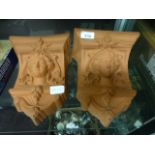 A pair of clay wall pockets depicting young ladies