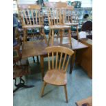 A pair of modern beech open arm rail back dining chairs together with a pair of matching standard