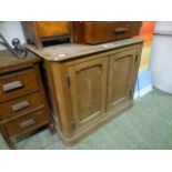 An early 20th century pitch pine two door cupboard