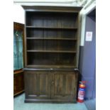 An early 20th century and later bookcase, the adjustable open shelving over two twin panel doors, h.