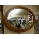 A wooden framed oval bevelled glass wall mirror