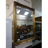 A reproduction ornate gilt framed bevel glass wall mirror