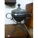An eastern style copper lidded pot on stand