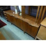 A mid 20th century teak side board, three cupboard doors along side three drawers,