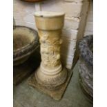 A weathered stoneware garden pedestal