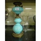 A green glass and brass effect oil lamp with shade