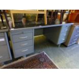 An early 20th century industrial twin pedestal desk