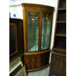 A modern bow front yew veneered floor standing corner cupboard,