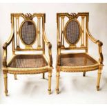 BERGERES, a pair, Belle Epoque style painted and parcel gilt with cane panelled backs and seats.