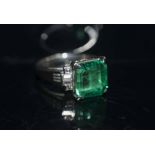 A FINE EMERALD AND DIAMOND RING, the square cut emerald of excellent colour and purity, weighing 4.