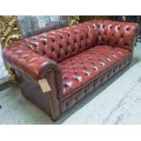 CHESTERFIELD SOFA, 20th century deep buttoned red leather upholstery raised on bun supports,