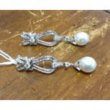 EARRINGS, a pair, of diamond bows with pearl drops, 18ct white gold approx 3cts.