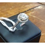 DIAMOND RING, of a single 'Old European' cut diamond within diamond bordered setting,