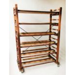 BAKERS RACK, early 20th century French beech with open shelves and castors,