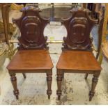 HALL CHAIRS, a pair, Victorian mahogany with cartouche backs.