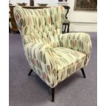 WING ARMCHAIR, circa 1960's, button backed patterned upholstery on ebonised legs,