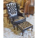 WING ARMCHAIR, Georgian style in buttoned black leather 109cm H x 83cm and a matching stool 56cm W.