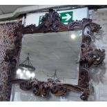 WALL MIRROR, stained pine, carved with scrolled detail, 150cm W x 125cm H.