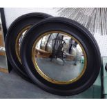BUTLERS MIRRORS, a pair, Regency style with ebonised and gilt frames, 76cm diam.