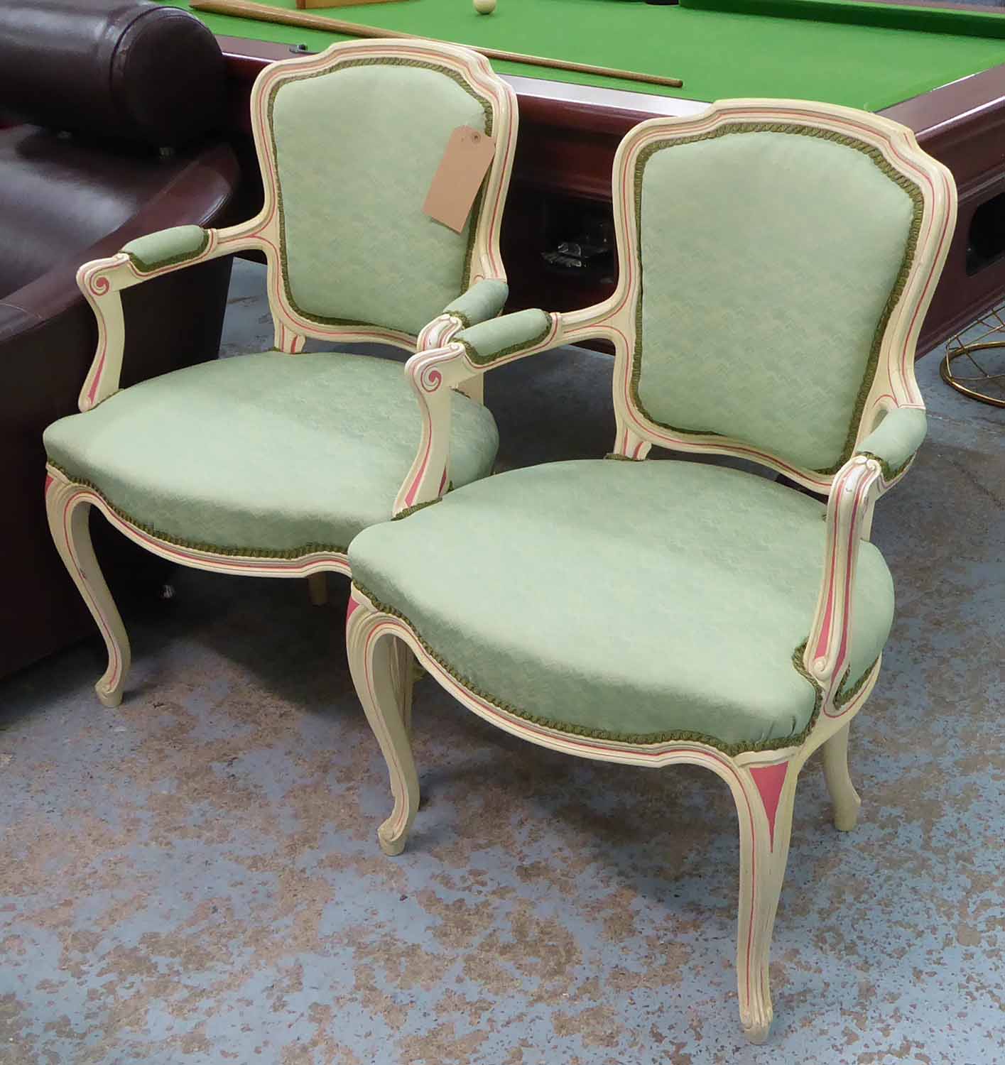 FAUTEUILS, a pair, painted cream show frames with pink detail and green upholstery, 62cm x 92cm H.