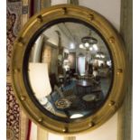 BUTLERS MIRROR, convex plate in ebonised edged gilt frame, 45cm diam. overall.