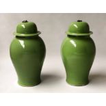 TEMPLE JARS, a pair, Chinese leaf green ceramic in the form of ginger jars with lids, 54cm H.