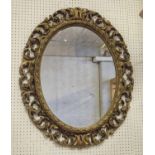 WALL MIRROR, oval with a scrolled gilt frame, 89cm H x 75cm.