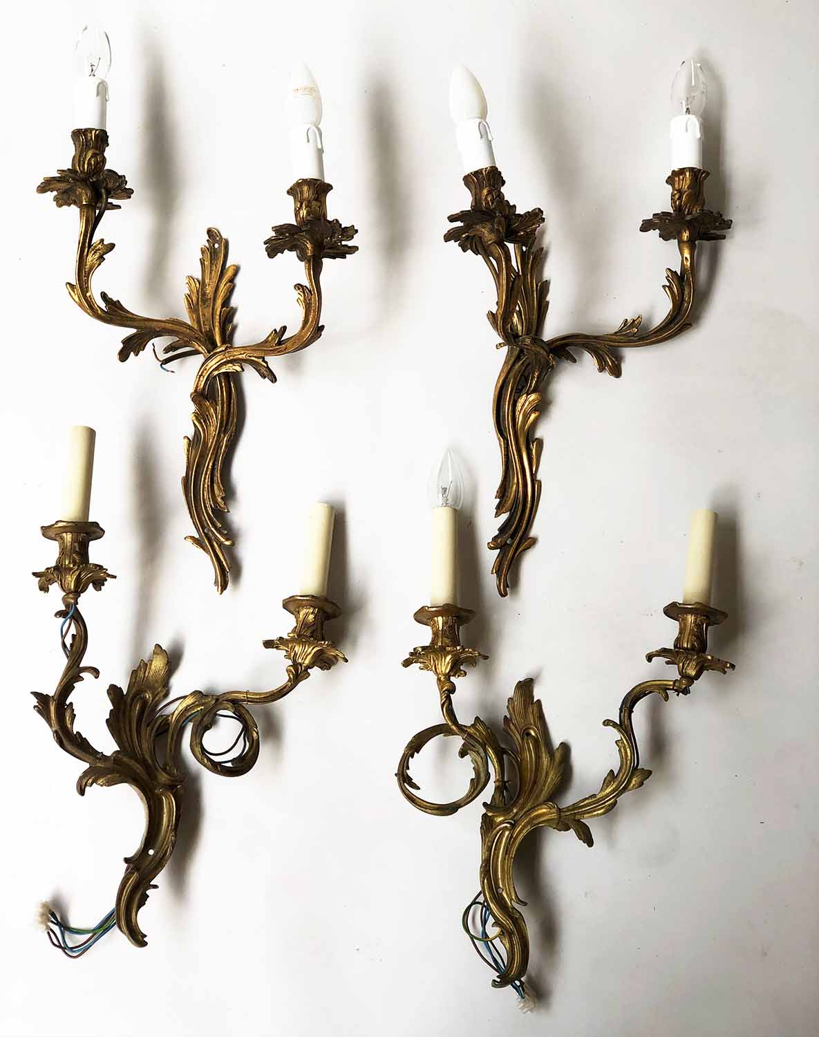 WALL LIGHTS, a set of three, Louis XV style, gilt metal, each foliate two branch,