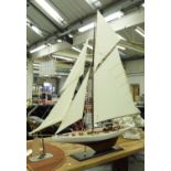 MODEL YACHT, with substantial sails, on ebonised stand, 150cm H x 144cm W.