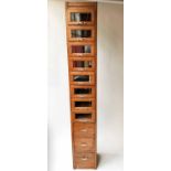 HABERDASHERY CABINET, mid century oak with eight glass fronted drawers above three further drawers,