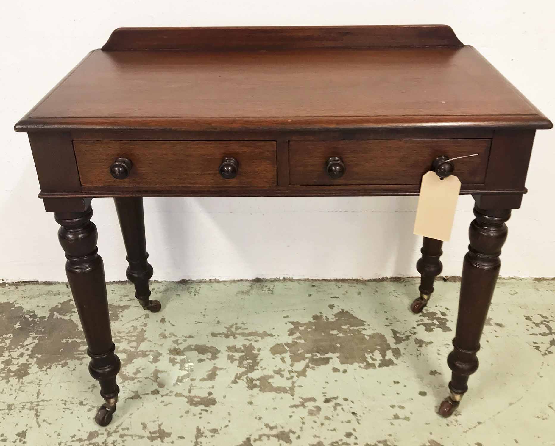 WRITING TABLE, Victorian mahogany with two frieze drawers on turned supports and ceramic castors,