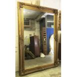WALL MIRROR, of large proportions, with a bevelled plate within an ornate gilt composite frame,