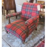 LOW ARMCHAIR, Victorian walnut, in red tartan upholstery on turned supports and castors,