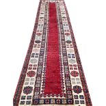 FINE KAZAK RUNNER, 390cm x 90cm, ruby open field within multiple geometric borders.