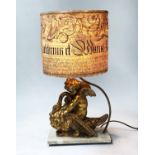 LAMP, gilded in the form of a cherub and swan on marble base, with parchment shade, 63cm H.
