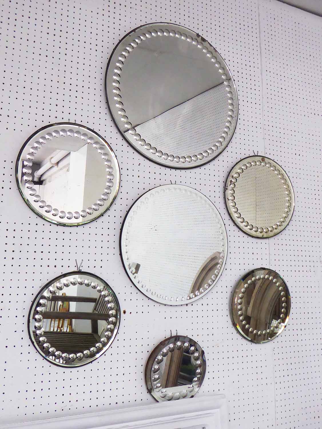 ENGLISH BULLSEYE BEVELED MIRRORS, a collection of seven, early 20th century (one later),