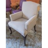 ARMCHAIR, in ticking with carved cabriole supports and splayed back legs with paw supports,